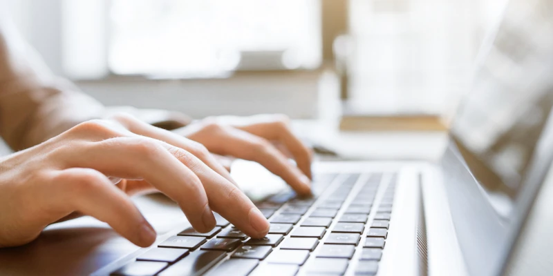 Close up of hands typing on a computer keyboard